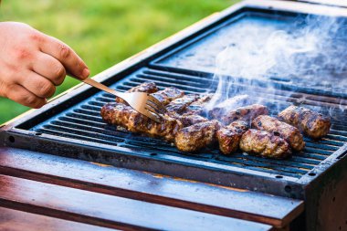 Mangalda mici ya da mititei denilen rulo köfteleri hazırlıyorum. Izgarayı alev ve dumanla yakın..