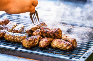 Mangalda mici ya da mititei denilen rulo köfteleri hazırlıyorum. Izgarayı alev ve dumanla yakın..