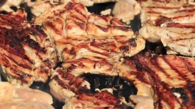 Izgarada yanan kömürlerde baharatlı ve otlu sulu et bifteği, alevler ve duman.