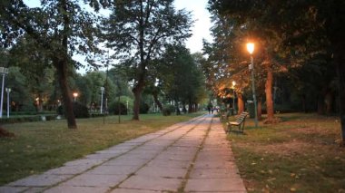 Romanya 'nın Bükreş kentindeki Carol Park' ın ana caddesinde yürüyen insanlar