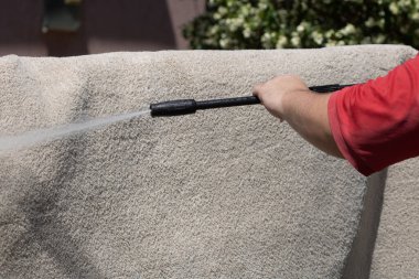 Yüksek basınçlı yıkamalı halılar. Yüksek basınçlı suyu yıkamak için halıyı silahla temizlemek.