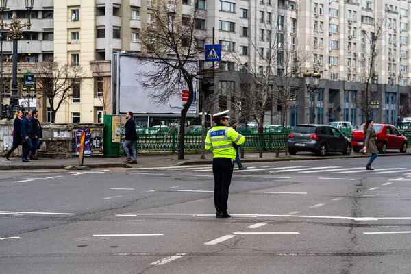 Police agent, Romanian Traffic Police (Politia Rutiera) directing traffic during  rush hour in downtown Bucharest, Romania, 2021