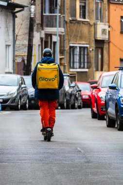 Romanya 'nın Bükreş kentinde bisikletli bir Glovo gıda kuryesi, 2022