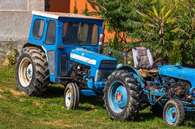 Romanya 'nın Viscri Köyü' ndeki tarım arazisinin önünde eski mavi vintage traktör