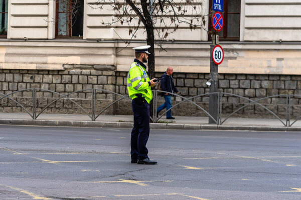 Police agent, Romanian Traffic Police (Politia Rutiera) directing traffic during  rush hour in downtown Bucharest, Romania, 2021