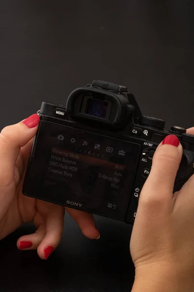デジタル写真カメラを使用して手 ブカレスト ルーマニア 2021年の黒い木製の背景にあるミラーレスカメラ — ストック写真