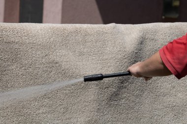 Yüksek basınçlı yıkamalı halılar. Yüksek basınçlı suyu yıkamak için halıyı silahla temizlemek.