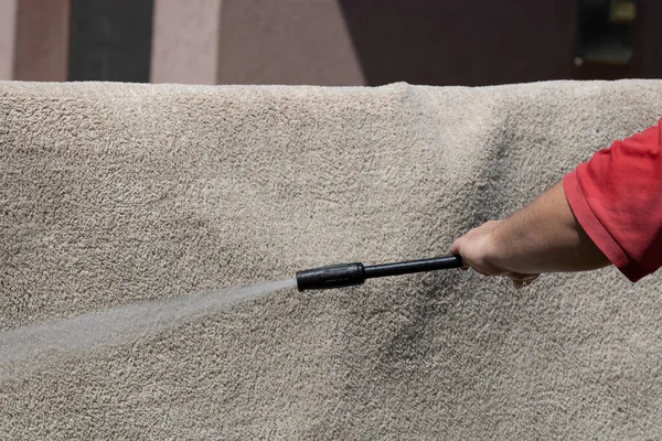 Yüksek basınçlı yıkamalı halılar. Yüksek basınçlı suyu yıkamak için halıyı silahla temizlemek.