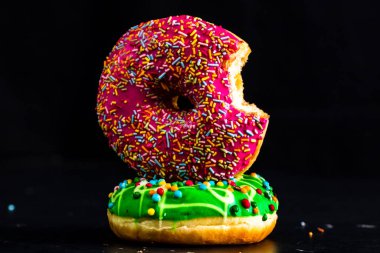 Isırılmış pembe jöleli donut. Renkli donutları kapat.