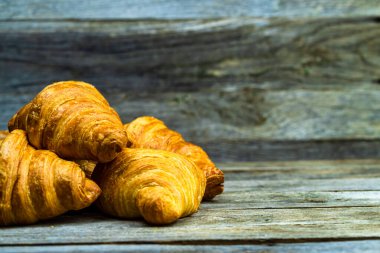 Tahtaya izole edilmiş lezzetli, taze kruvasanlar. Fransız kahvaltı konsepti.