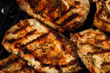 Izgara domuz bifteği. Lezzetli biftekler ızgarada yakın pişiyor.