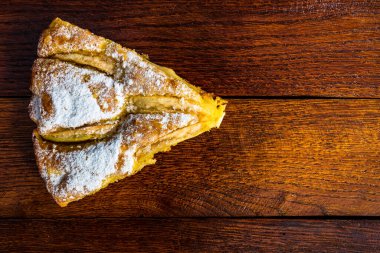 Kırsal ahşap masada tarçınlı dilimlenmiş elmalı turta.