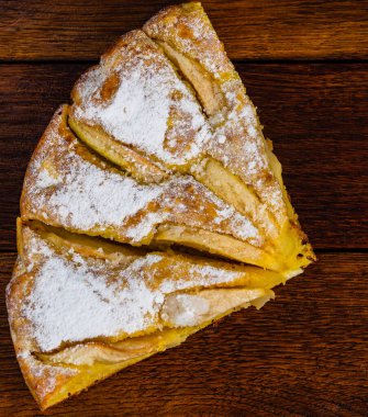 Tahtaya şeker tozu sürülmüş taze pişmiş elmalı turta. Ev yapımı elmalı pasta..