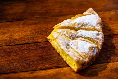 Tahtaya şeker tozu sürülmüş taze pişmiş elmalı turta. Ev yapımı elmalı pasta..