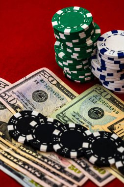 Kırmızı arka planda parası olan poker çipleri yığını