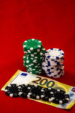 Kırmızı arkaplanda parası olan poker çipleri yığını, EURO para birimi