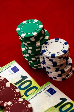 Kırmızı arkaplanda parası olan poker çipleri yığını, EURO para birimi