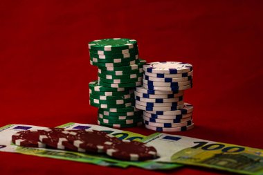 Kırmızı arkaplanda parası olan poker çipleri yığını, EURO para birimi