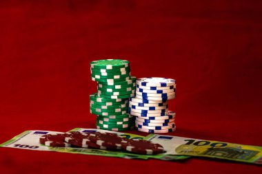 Kırmızı arkaplanda parası olan poker çipleri yığını, EURO para birimi