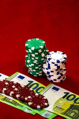 Kırmızı arkaplanda parası olan poker çipleri yığını, EURO para birimi