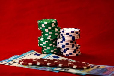 Kırmızı arkaplanda parası olan poker çipleri yığını, EURO para birimi