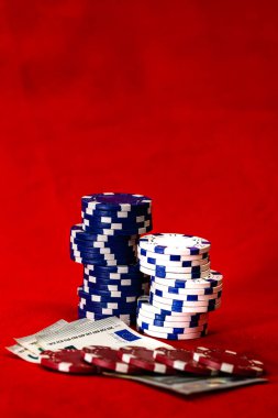 Kırmızı arkaplanda parası olan poker çipleri yığını, EURO para birimi