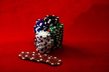 Kırmızı arkaplanda poker çiplerinin karışımı
