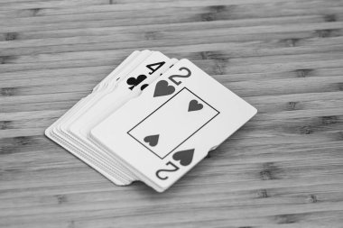 İskambil kağıtları kapalı, ahşap masada izole. Kumarhane konsepti, risk, şans, iyi şans veya kumar.