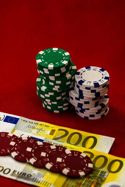Kırmızı arkaplanda parası olan poker çipleri yığını, EURO para birimi