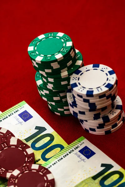 Kırmızı arkaplanda parası olan poker çipleri yığını, EURO para birimi