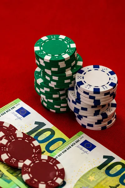 Kırmızı arkaplanda parası olan poker çipleri yığını, EURO para birimi