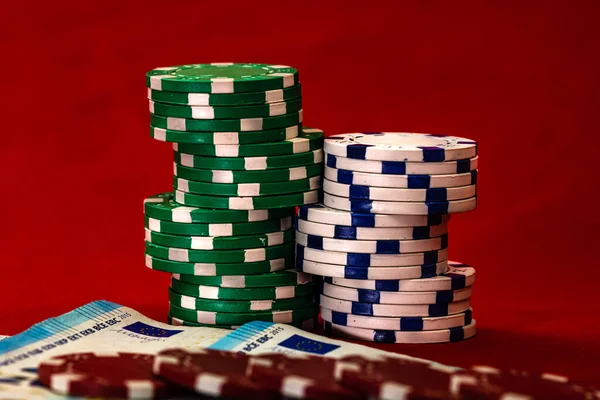 Kırmızı arkaplanda parası olan poker çipleri yığını, EURO para birimi