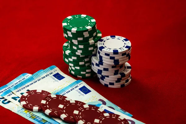 Stacks of poker chips with money on red background, EURO currency