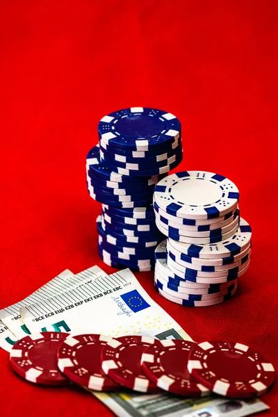 Kırmızı arkaplanda parası olan poker çipleri yığını, EURO para birimi