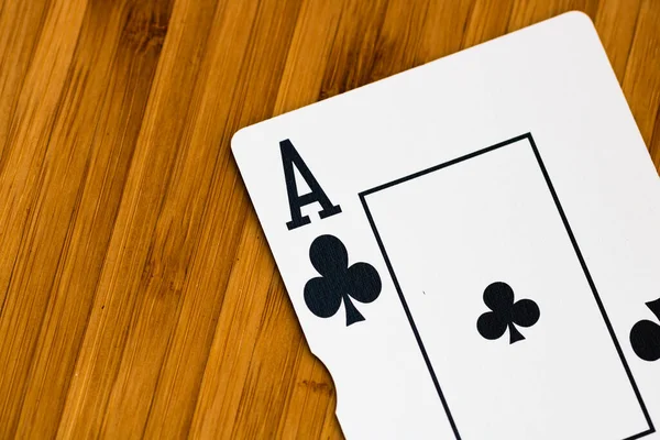 Playing cards ace card close up, isolated on wooden table. Casino concept, risk, chance, good luck or gambling.