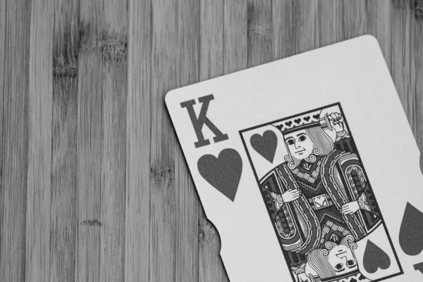 Playing cards king card close up, isolated on wooden table. Casino concept, risk, chance, good luck or gambling.