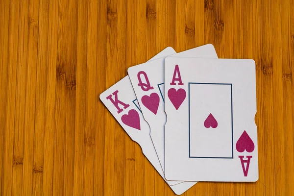 Playing cards king queen ace cards close up, isolated on wooden table. Casino concept, risk, chance, good luck or gambling