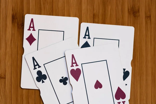 Playing cards aces card close up, isolated on wooden table. Casino concept, risk, chance, good luck or gambling.