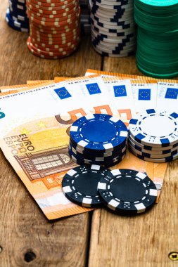 Poker fişleri ve para yakında. Kumarhane konsepti, risk, şans, iyi şans veya kumar. Kumarhane fişleri, EURO, Amerikan doları.