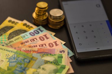 Romen para birimi Lei mobil hesap makinesiyle siyah zemin üzerinde. Para, vergi, haber kavramı