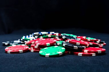Mix of poker chips on black background clipart