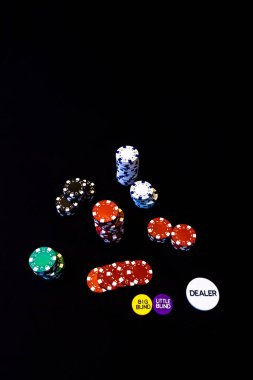 Siyah arkaplanda poker çipleri yığını
