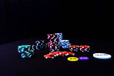 Siyah arkaplanda poker çipleri yığını