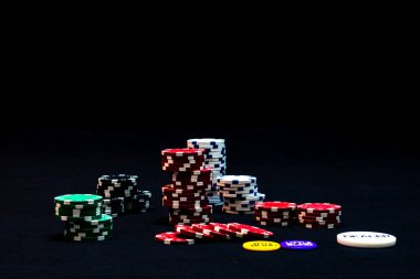Siyah arkaplanda poker çipleri yığını