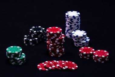 Siyah arkaplanda poker çipleri yığını