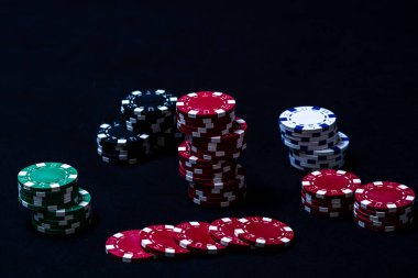Siyah arkaplanda poker çipleri yığını