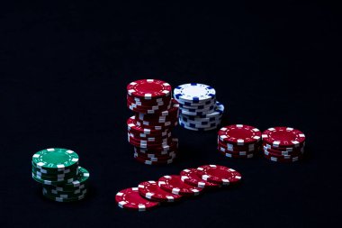 Siyah arkaplanda poker çipleri yığını