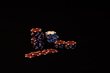 Siyah arkaplanda poker çipleri yığını