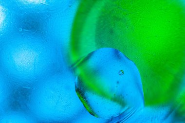 Su yüzeyinde yağ damlaları ve dalgaları olan soyut renkli arkaplan. Soyut arkaplan kavramı