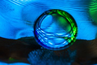 Su yüzeyinde yağ damlaları ve dalgaları olan soyut renkli arkaplan. Soyut arkaplan kavramı